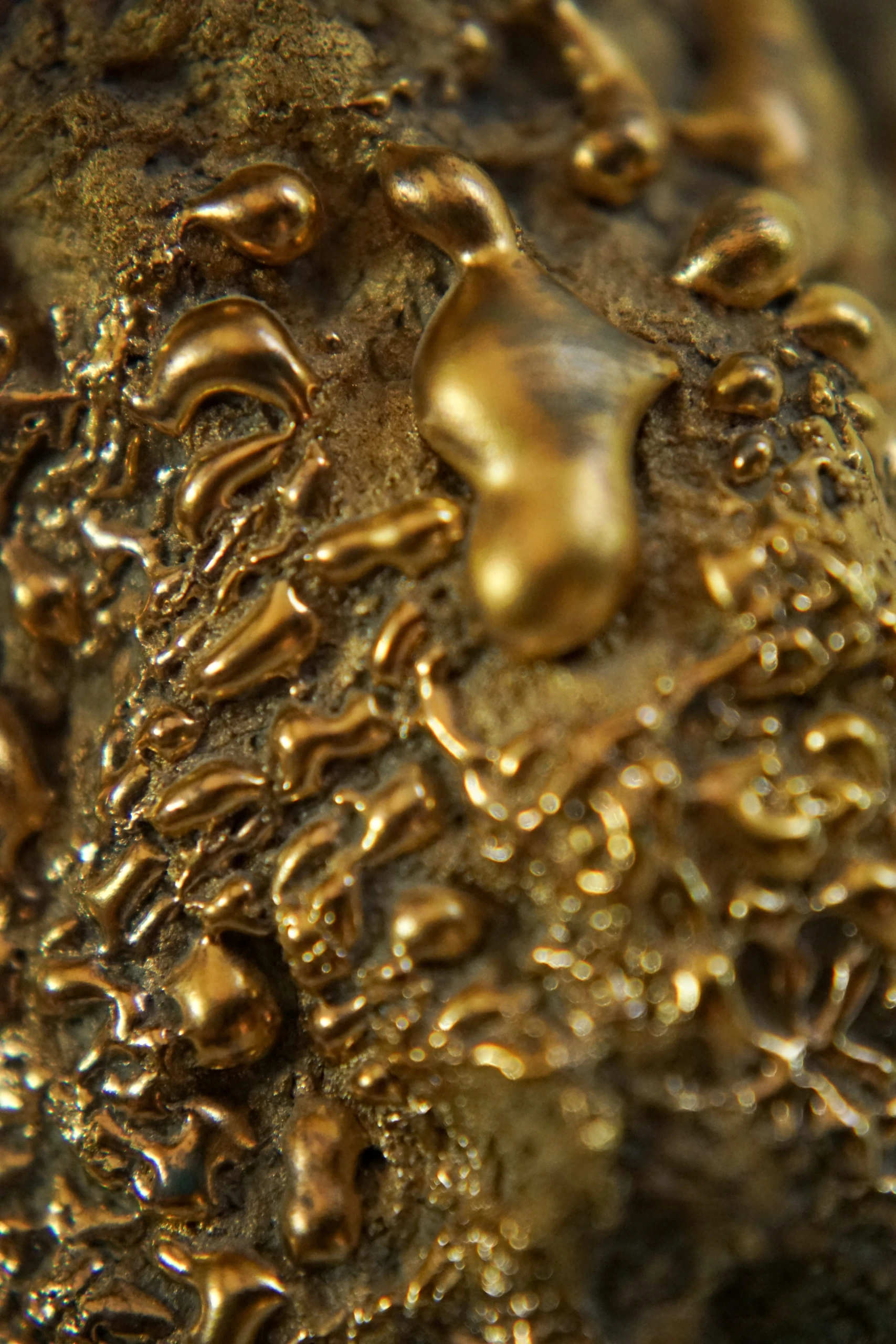 Gold Roundhead (2026), ceramic sculpture by Sjors Driessen with a tall elongated mushroom-like form covered in textured glaze and reflective gold lustre.