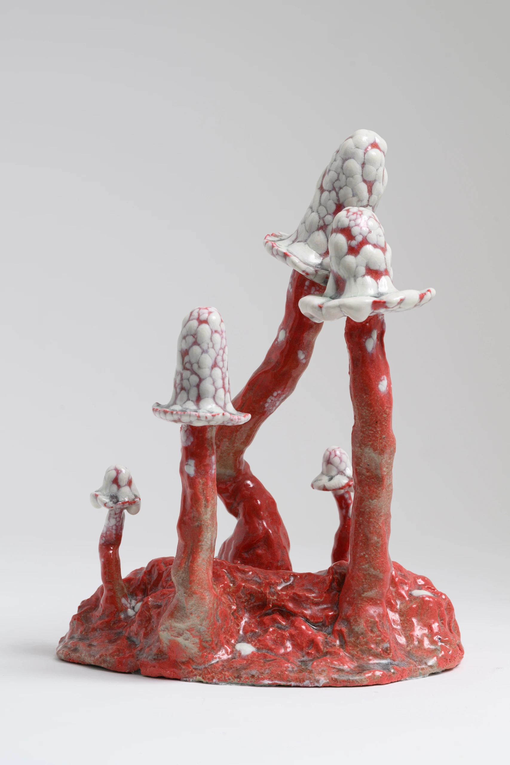Red Inkcap (2024), ceramic sculpture by Sjors Driessen with two tall curved red stems and white textured mushroom caps.