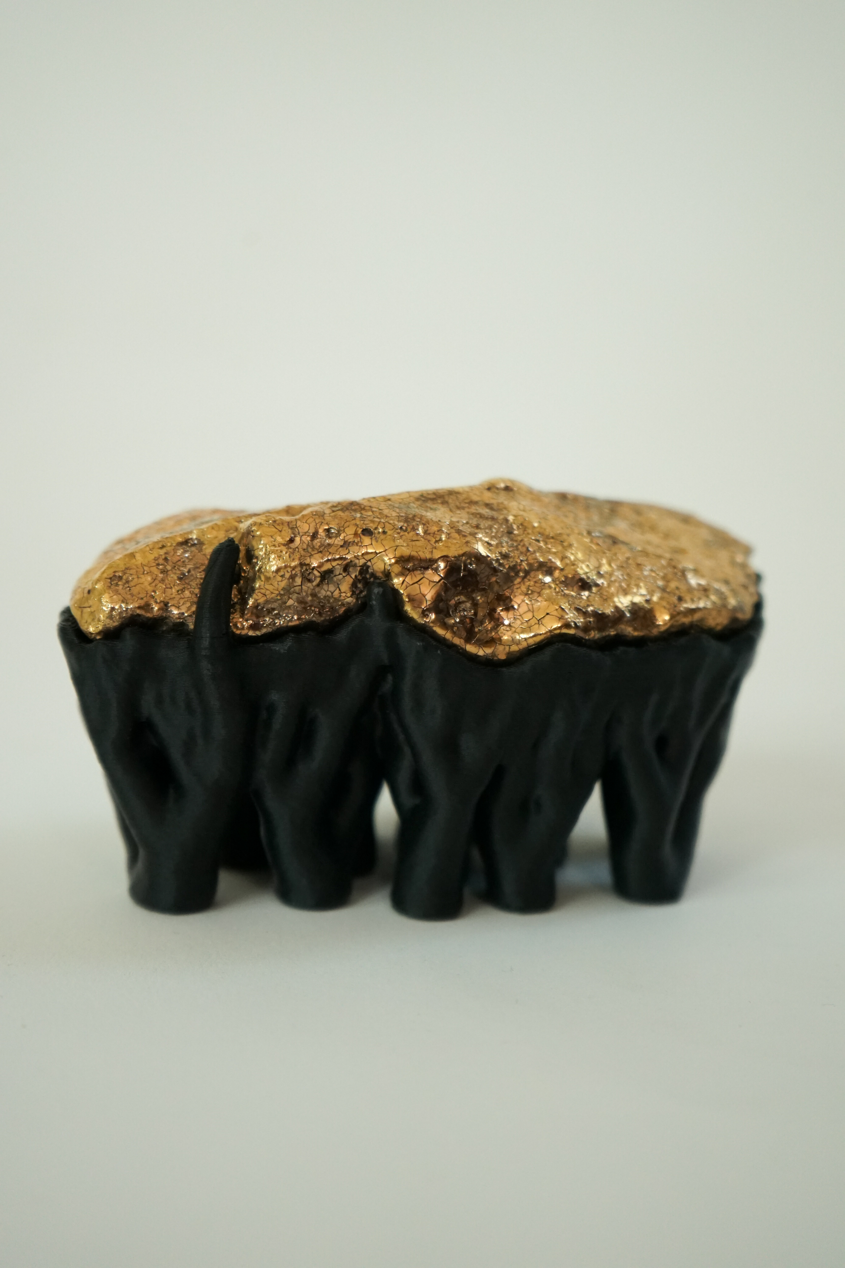 Black Hyphae III (2026), sculpture by Sjors Driessen with three stone forms finished with gold glaze and lustre, supported by matte black branching hyphae-like structures.