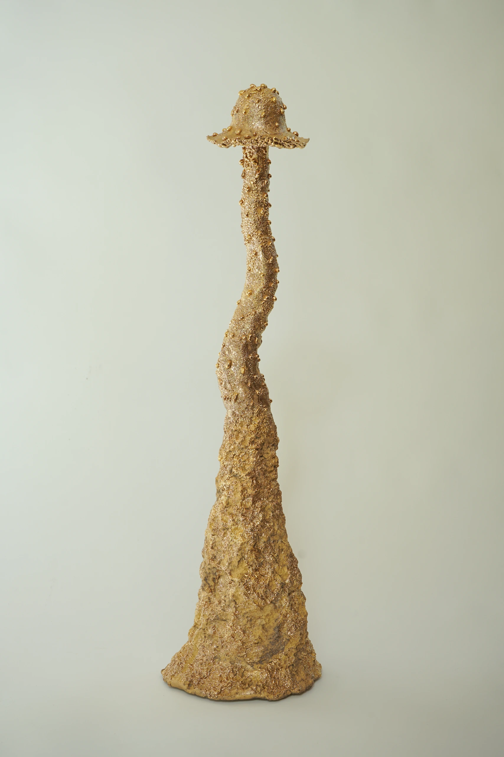 Gold Roundhead (2026), ceramic sculpture by Sjors Driessen with a tall elongated mushroom-like form covered in textured glaze and reflective gold lustre.
