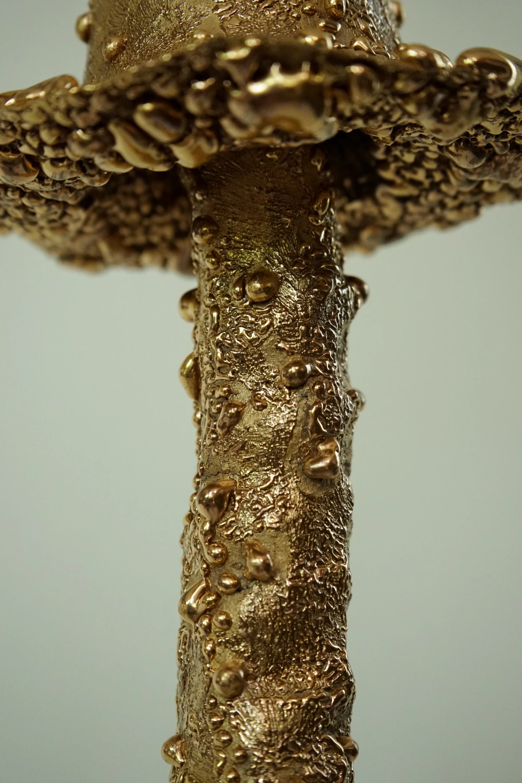 Gold Roundhead (2026), ceramic sculpture by Sjors Driessen with a tall elongated mushroom-like form covered in textured glaze and reflective gold lustre.