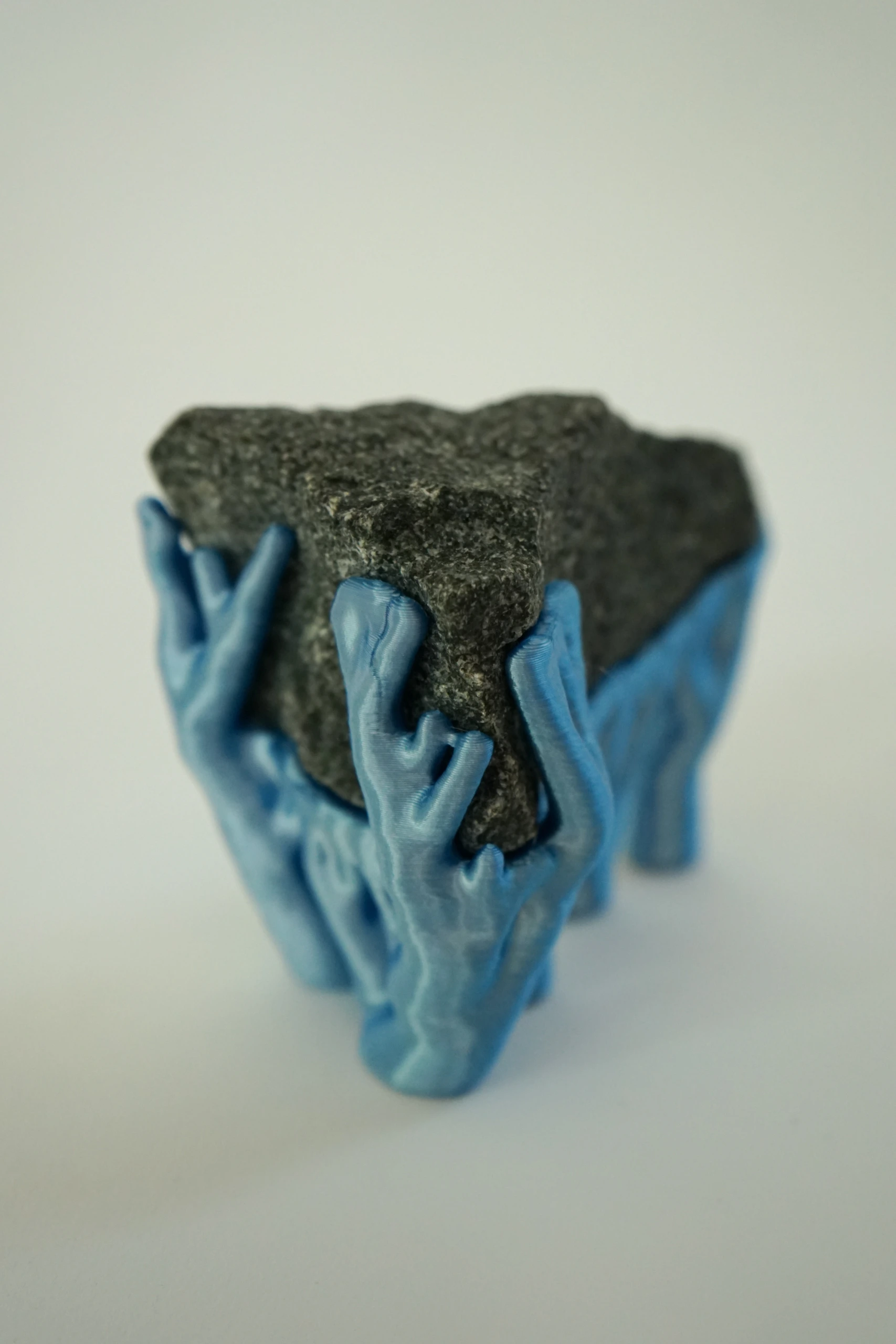 Blue Hyphae III (2026), sculpture by Sjors Driessen with three dark olivine diabase stones supported by bright blue branching hyphae-like structures.