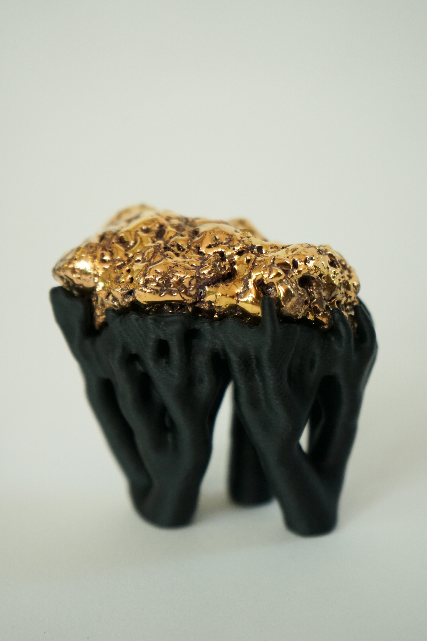 Black Hyphae III (2026), sculpture by Sjors Driessen with three stone forms finished with gold glaze and lustre, supported by matte black branching hyphae-like structures.