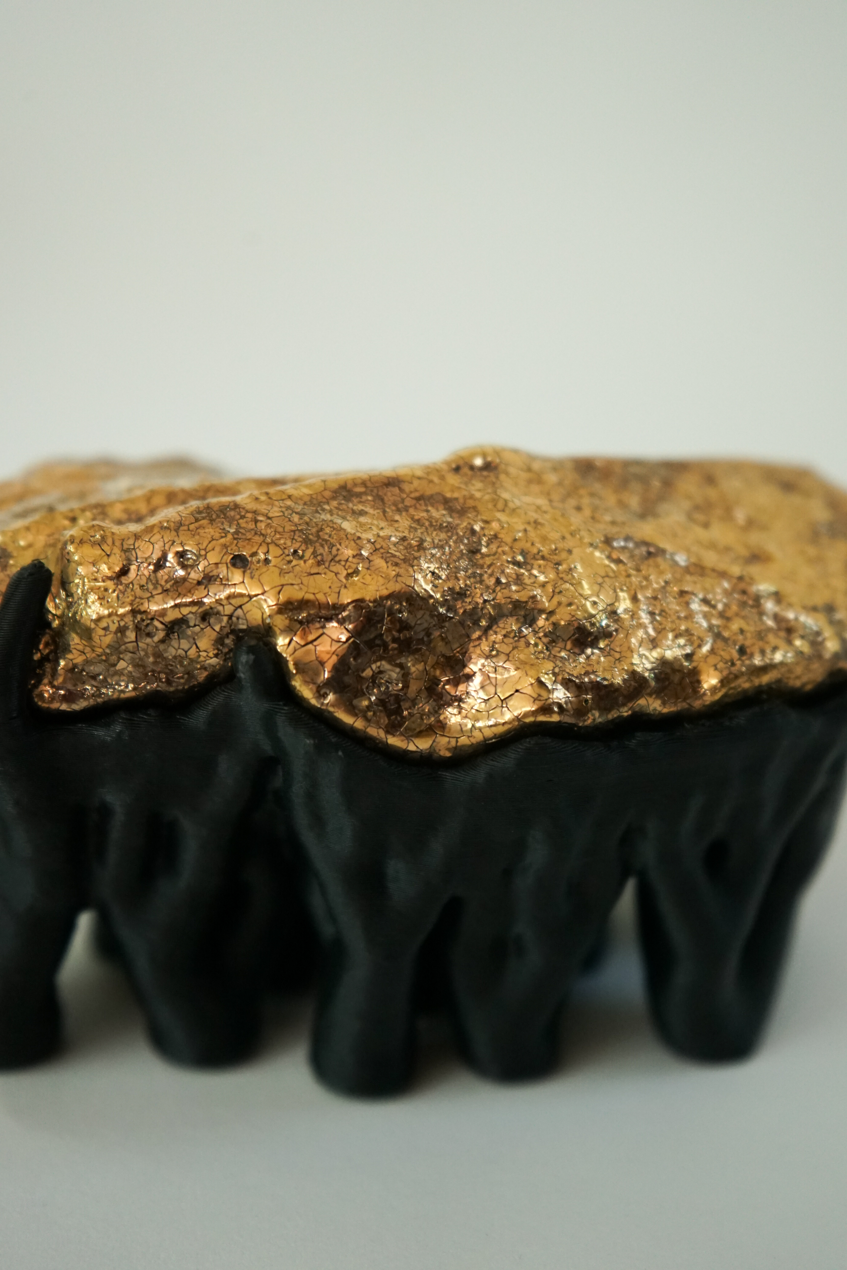 Black Hyphae III (2026), sculpture by Sjors Driessen with three stone forms finished with gold glaze and lustre, supported by matte black branching hyphae-like structures.