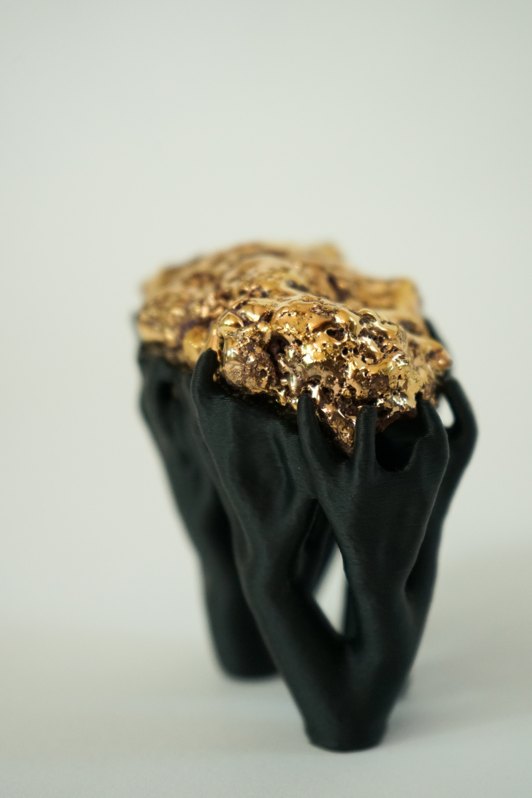 Black Hyphae III (2026), sculpture by Sjors Driessen with three stone forms finished with gold glaze and lustre, supported by matte black branching hyphae-like structures.