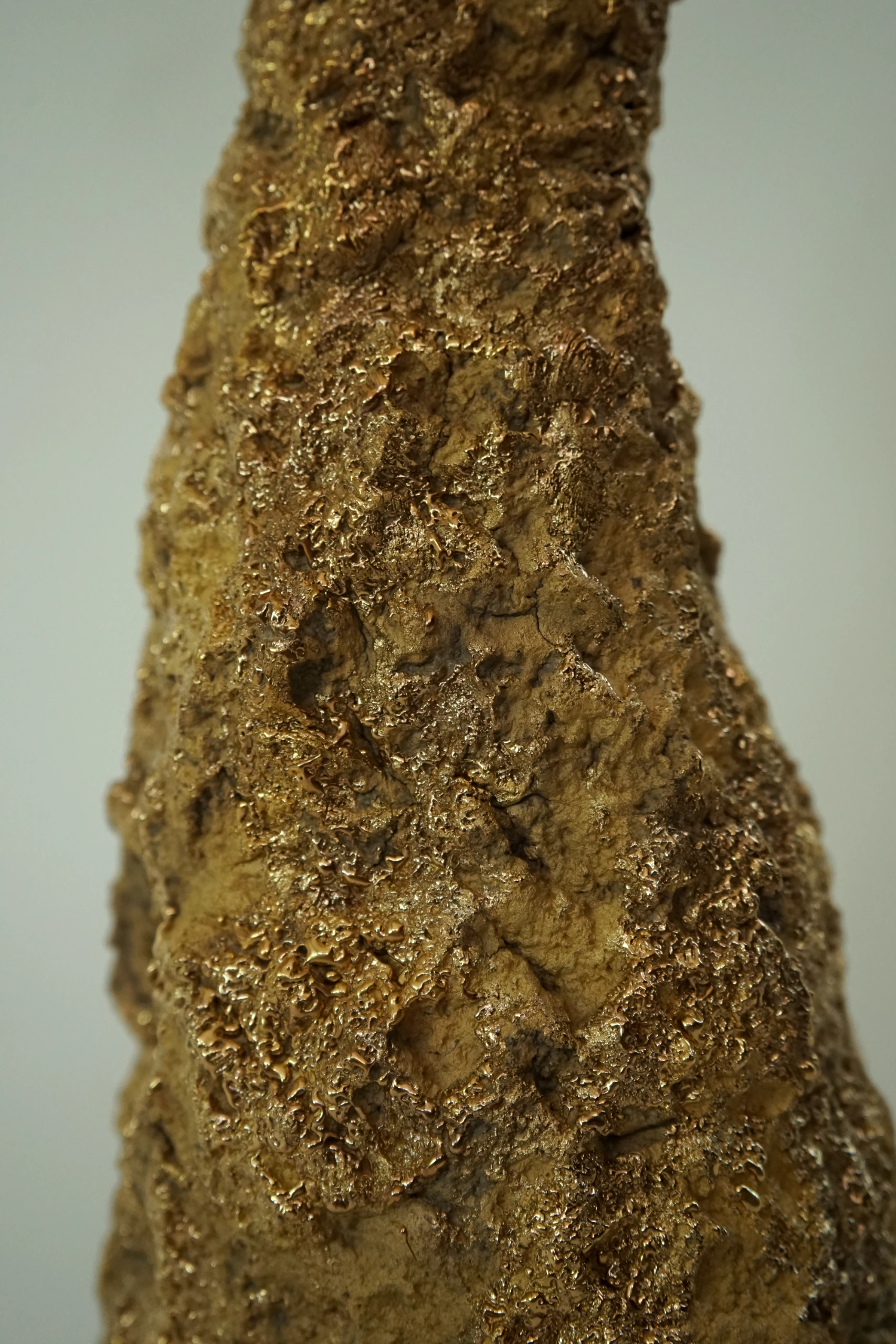 Gold Roundhead (2026), ceramic sculpture by Sjors Driessen with a tall elongated mushroom-like form covered in textured glaze and reflective gold lustre.